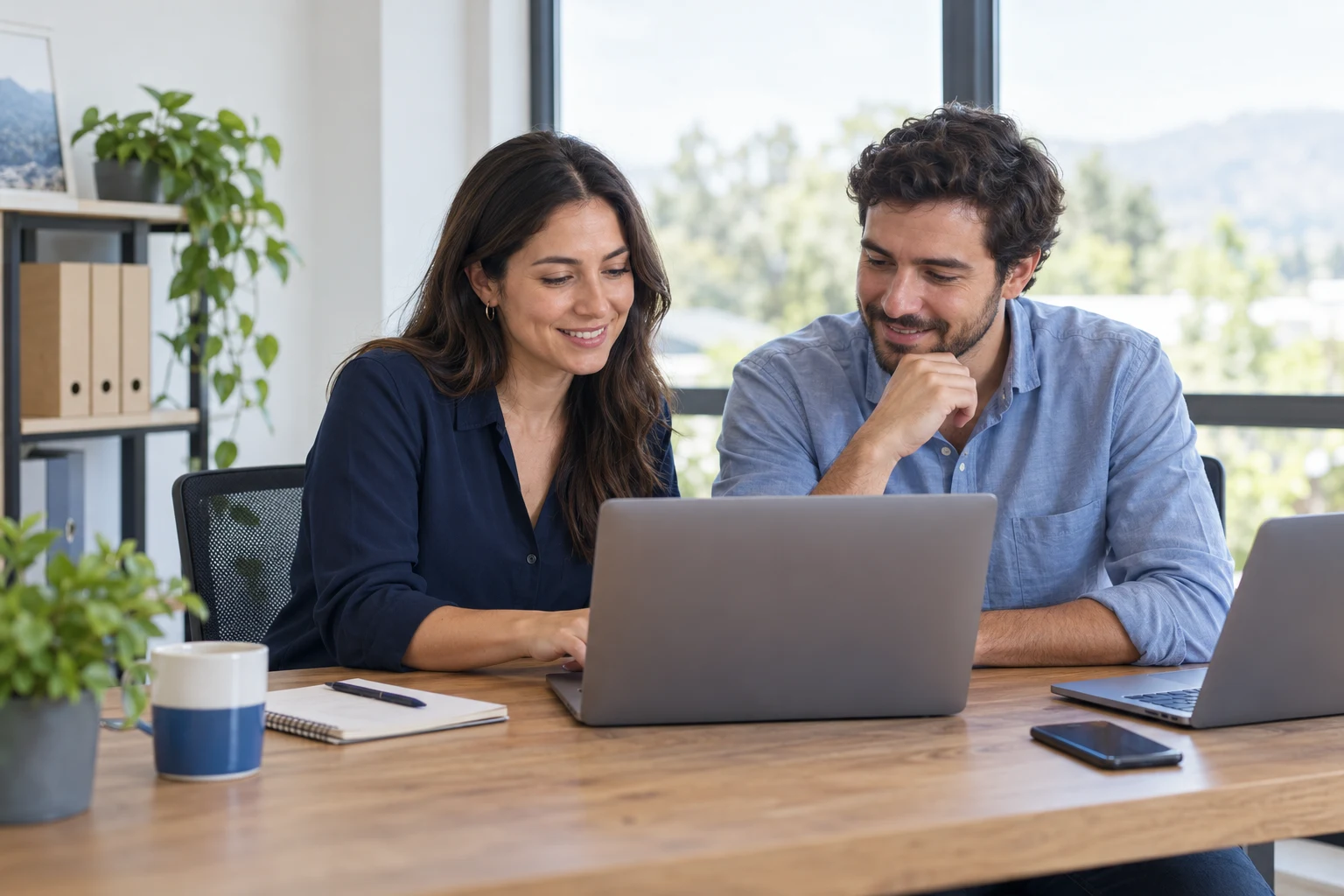 Dos personas de una pequeña empresa trabajan juntas frente a un computador